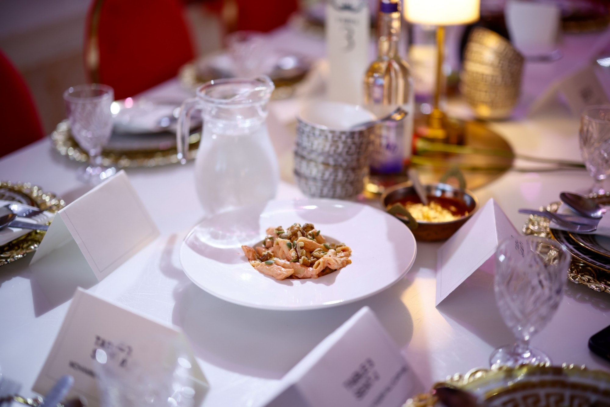 A plated course on a dressed table, with glassware and place cards